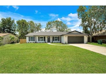 Charming single-story home featuring a well-manicured lawn, attached two car garage, and inviting curb appeal at 1917 Alameda Dr, Deltona, FL 32738