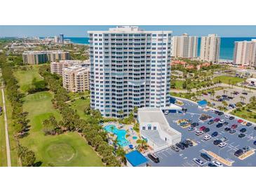 Stunning aerial view of a high-rise condo, golf course, swimming pool, parking, and beach access at 2 Oceans West Blvd # 305, Daytona Beach, FL 32118