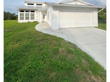 Charming home with a large two car garage and lush front yard with a curved sidewalk leading to the front door at 2689 Courtland Blvd, Deltona, FL 32738