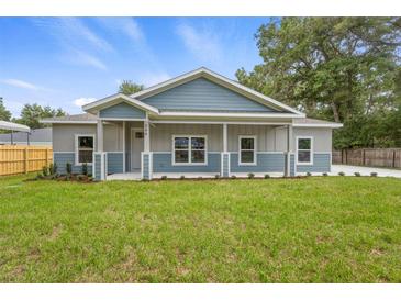 Charming, newly built single-Gathering home featuring a covered front porch, green lawn, and modern two-tone exterior at 349 Baker Ave, Lake Helen, FL 32744