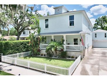 Charming two-story home with a well-manicured lawn, white picket fence, and inviting front porch at 417 S Palmetto Ave, Daytona Beach, FL 32114