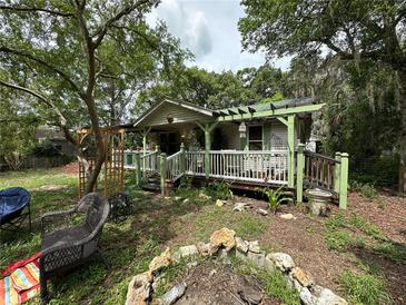 Charming cottage-style home featuring a cozy covered porch and beautifully landscaped front yard at 43721 State Road 19, Altoona, FL 32702