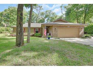 Charming one-story brick home featuring a well-manicured lawn and a welcoming front porch at 535 Black Ironwood Dr, Deland, FL 32724