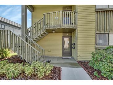 Inviting exterior view of the condo featuring a quaint walkway and staircase to upper level unit at 600 N Boundary Ave # 110A, Deland, FL 32720