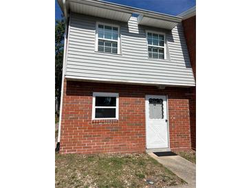 Charming two-story townhome with brick and gray siding, complemented by well-maintained landscaping at 621 W Indiana Ave # 13, Deland, FL 32720