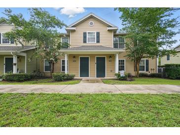 Inviting two-story townhome with manicured lawn, mature trees, and a charming covered entryway at 944 Regatta Bay Dr # 12-102, Orange City, FL 32763