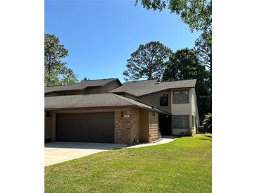 Two-story home with a brick front, attached garage and well-maintained lawn at 96 Old Barn Trl, Ormond Beach, FL 32174