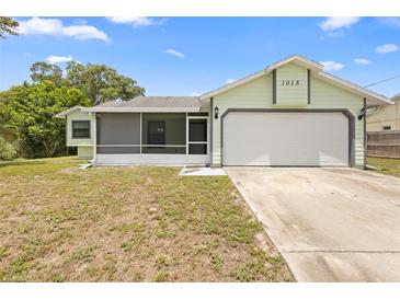 Charming single-story home featuring a two-car garage and a screened-in porch at 1018 E Gaucho Cir, Deltona, FL 32725