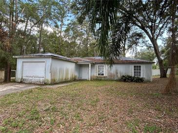 A single-Gathering home featuring an attached one-car garage and a front yard with mature trees at 1370 19Th St, Orange City, FL 32763