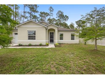 Charming single-story home featuring a well-manicured lawn and a welcoming front entrance and a two-car garage at 1683 10Th Ave, Deland, FL 32724
