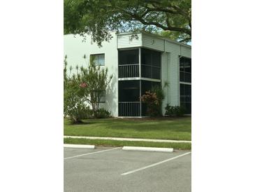 A two-story condo with screened balconies and lush green lawn and landscaping at 2565 Oak Park Way # 213, Orlando, FL 32822