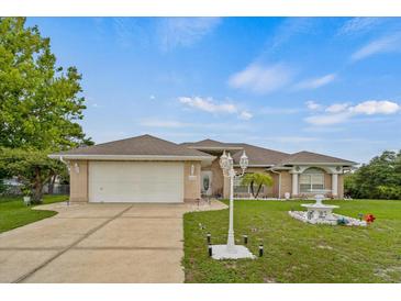 Charming single-Gathering home featuring a well-manicured lawn, complemented by a decorative fountain and brick facade at 2880 Boyd Ct, Deltona, FL 32738