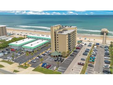 Aerial view of a beachfront condo building with ample parking and ocean views, perfect for coastal living at 3647 S Atlantic Ave # 7C, Daytona Beach, FL 32118