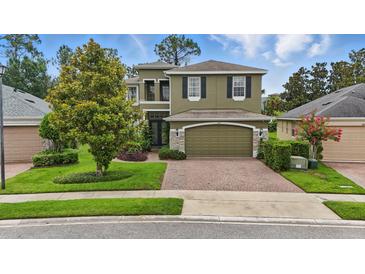 Charming two-story home featuring a brick driveway and a well-manicured lawn at 3839 Calliope Ave, Port Orange, FL 32129