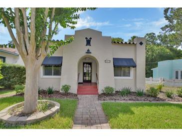Charming stucco home with a beautiful front yard, walkway, and well-maintained landscaping at 441 N Julia Ave, Deland, FL 32720