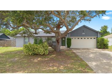 Charming single-Gathering home featuring a lush front yard with mature trees and a welcoming two-car garage at 510 Apollo Ave, Deltona, FL 32725