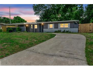 Charming one-story home with a long driveway and inviting curb appeal at dusk at 5204 Van Aken Dr, Orlando, FL 32808