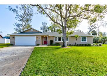Charming single Gathering home featuring a large front yard and a two-car garage at 65 Sycamore Cir, Ormond Beach, FL 32174