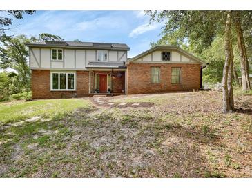 Two-story brick home featuring a red front door and a well-maintained yard at 658 Westchester Dr, Deland, FL 32724