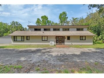 Unique home exterior with a blend of modern and traditional elements, under a bright blue sky at 910 Braddock Rd, Enterprise, FL 32725