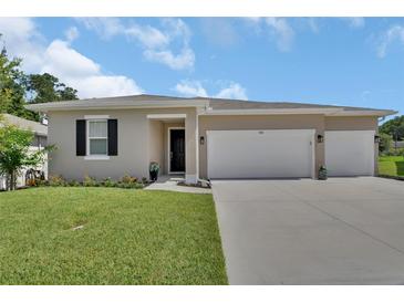 Charming single-story home with a well-manicured lawn and a spacious three-car garage at 1018 River Falls Cir, Deland, FL 32720