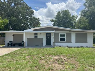 Charming one-story home with a manicured lawn and inviting front porch seating at 1215 N Boston Ave, Deland, FL 32724