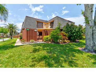Charming condo featuring a well-manicured lawn, fenced front patio, and a small second story balcony at 122 Cedar Dunes Dr, New Smyrna Beach, FL 32169