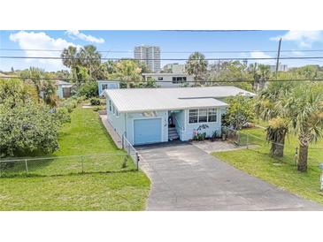 Charming light blue single-story home with a metal roof, a single-car garage, and a well-maintained lawn at 1420 N Grandview Ave, Daytona Beach, FL 32118