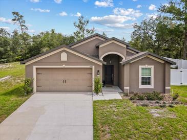 Charming single-story home featuring a two-car garage, well-manicured lawn, and a stylish front entrance at 1846 N Acadian Dr, Deltona, FL 32725