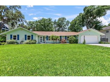 Charming single-story home with a lush green lawn and colorful exterior paint at 204 Rio Pinar Dr, Ormond Beach, FL 32174