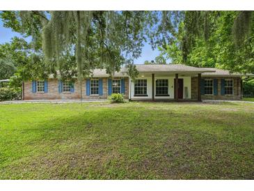 Charming single-story brick home featuring blue shutters and a lush green lawn at 2950 Ragis Rd, Edgewater, FL 32132