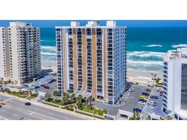 Coastal condo building featuring a manicured lawn, palm trees, and a convenient parking area at 3003 S Atlantic Ave # 3A2, Daytona Beach Shores, FL 32118