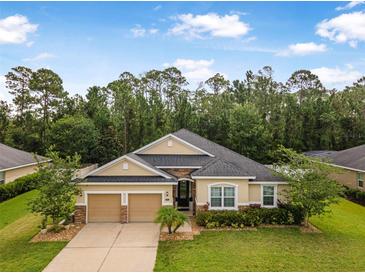 Charming single-story home with stone accents, lush landscaping, and a two-car garage at 31 Abacus Ave, Ormond Beach, FL 32174