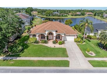 Beautiful one-story home with lush landscaping and a serene lake view creating an inviting curb appeal at 6083 Sabal Hammock Cir, Port Orange, FL 32128