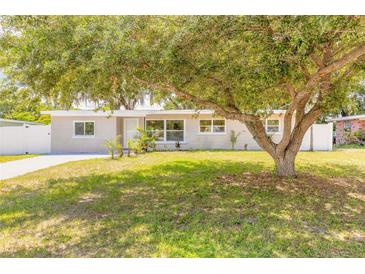 Charming single-story home featuring a well-maintained lawn and mature trees in a serene neighborhood at 118 N Sunland Dr, Sanford, FL 32773