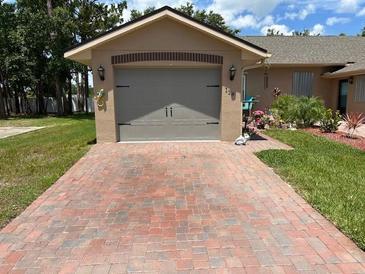 Charming home featuring a brick driveway and attached garage at 118 Tuscany Villas Dr, Edgewater, FL 32141