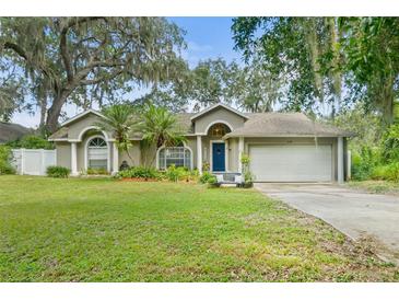 Charming single-story home with well-manicured lawn, mature trees, and a two-car garage in a serene neighborhood at 2163 Fireside Rd, Deltona, FL 32738