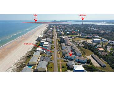 An aerial view of the beachfront property showing beach access, inlet, lighthouse, and parking at 4786 S Atlantic Ave # 3, Ponce Inlet, FL 32127