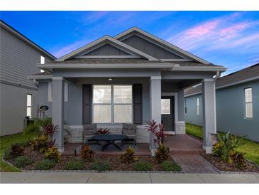 Charming single-story home with a well-manicured lawn and inviting front porch with chairs and landscaping at 614 Becklow St, Debary, FL 32713
