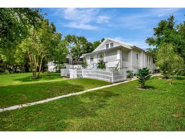 Charming home featuring a manicured lawn and a classic white picket fence, evoking a welcoming and picturesque curb appeal at 1056 Stevens St, Lake Helen, FL 32744