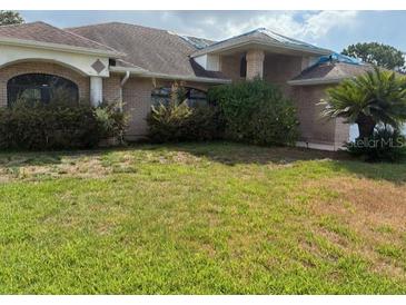 Lawn of a single Gathering home with mature landscaping and an attached two car garage at 1118 Prescott Blvd, Deltona, FL 32738