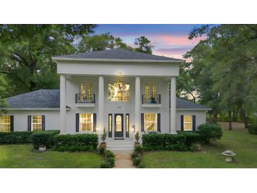 Stately white home featuring a grand facade with large columns and symmetrical design elements at 1155 Taylor E Rd, Deland, FL 32724