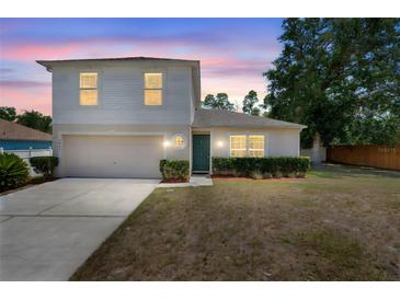 Charming two-story home with a well-maintained lawn, manicured shrubbery, and a two car garage at 1561 Randolph St, Deltona, FL 32725