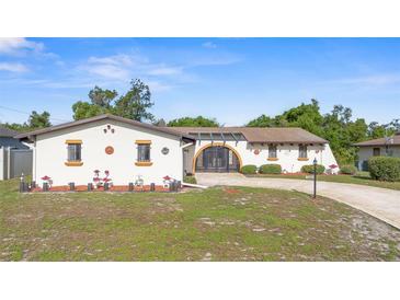 Charming single-story home showcasing a circular driveway and unique, decorative architectural details at 2080 Roseway Ave, Deltona, FL 32738