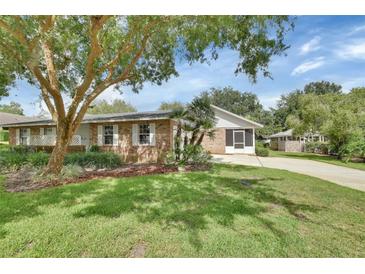 Charming brick home with mature landscaping and a well-manicured lawn at 2480 S Glen Eagles Dr, Deland, FL 32724
