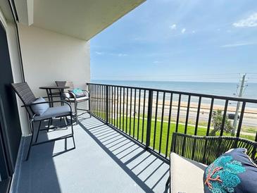 Outdoor balcony featuring chairs, table, and beautiful ocean view at 2860 Ocean Shore Blvd # 5020, Ormond Beach, FL 32176