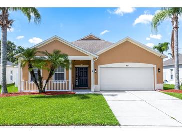 Charming single-story home featuring a two-car garage and tropical landscaping at 452 Casa Marina Pl, Sanford, FL 32771