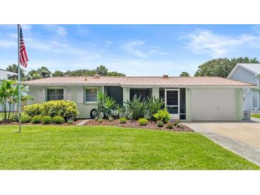 Charming single story home with a well-manicured lawn, beautiful landscaping, and a one-car garage at 4638 Saxon Dr, New Smyrna Beach, FL 32169