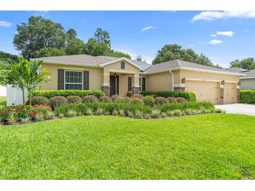 Inviting single-story home featuring lush landscaping, a well-manicured lawn, and a convenient three-car garage at 508 Morgan Wood Dr, Deland, FL 32724