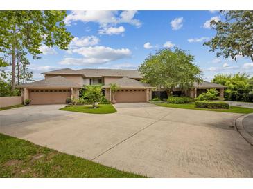 A well-maintained property with lush landscaping and a large driveway leading to multiple garages at 510 Sandy Bluff Trl, Deland, FL 32724